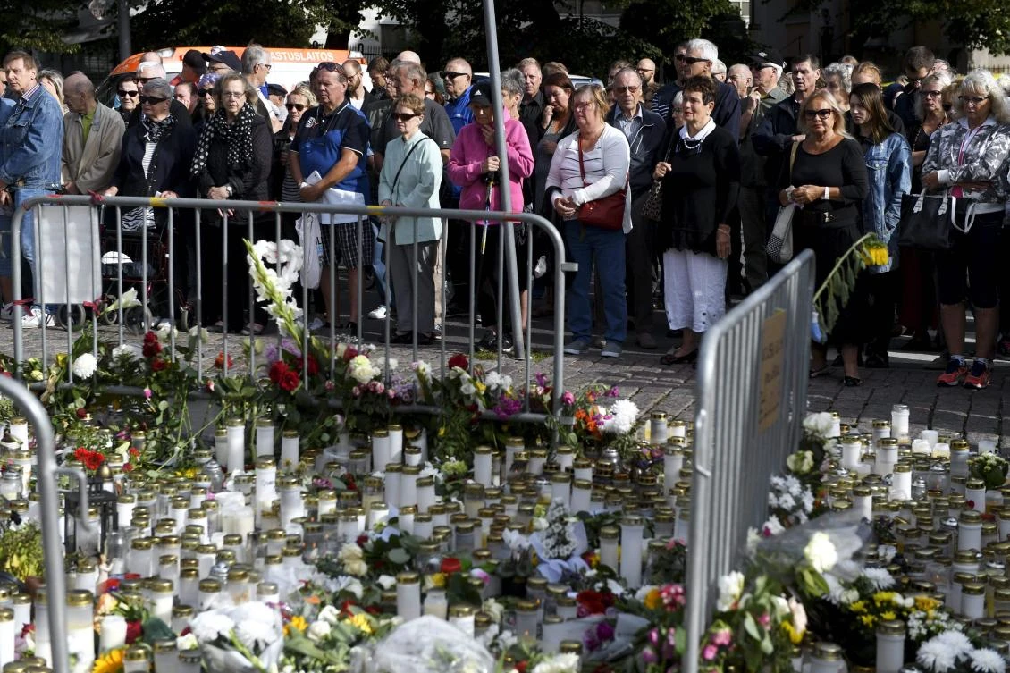 People held a minute’s silence in front of flowers and candles laid at a makeshift memorial at the Turku Market Square in Turku, Finland, on August 20, 2017. (AFP)