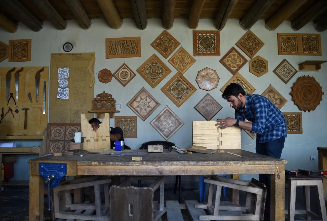 In this photograph taken on July 18, 2017 Afghan students work on a Jali wood carving during a Jali Screen Workshop at the Turquoise Mountain Foundation in Mourad Khani in the old city section of Kabul. Ceramics, carpentry, calligraphy and gem cutting: centuries of Afghan craftmanship honed on the ancient Silk Road are being preserved in Kabul, a rare success story for an aid project in the war-torn country that organisers are now hoping to replicate with refugees from Syria. - TO GO WITH "AFGHANISTAN-CULTURE-UNREST,FEATURE" by Anne Chaon / AFP / WAKIL KOHSAR / TO GO WITH "AFGHANISTAN-CULTURE-UNREST,FEATURE" by Anne Chaon