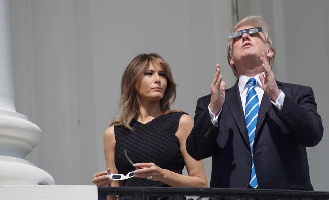 US President Donald Trump and First Lady Melania Trump look up at the partial solar eclipse from the balcony of the White House in Washington, DC, on Monday. (AFP)