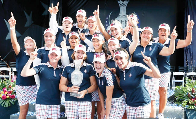 US captain Juli Inkster, center, holds the Solheim Cup as she celebrates with her team after winning the Solheim Cup golf tournament Sunday in West Des Moines, Iowa. (AP)