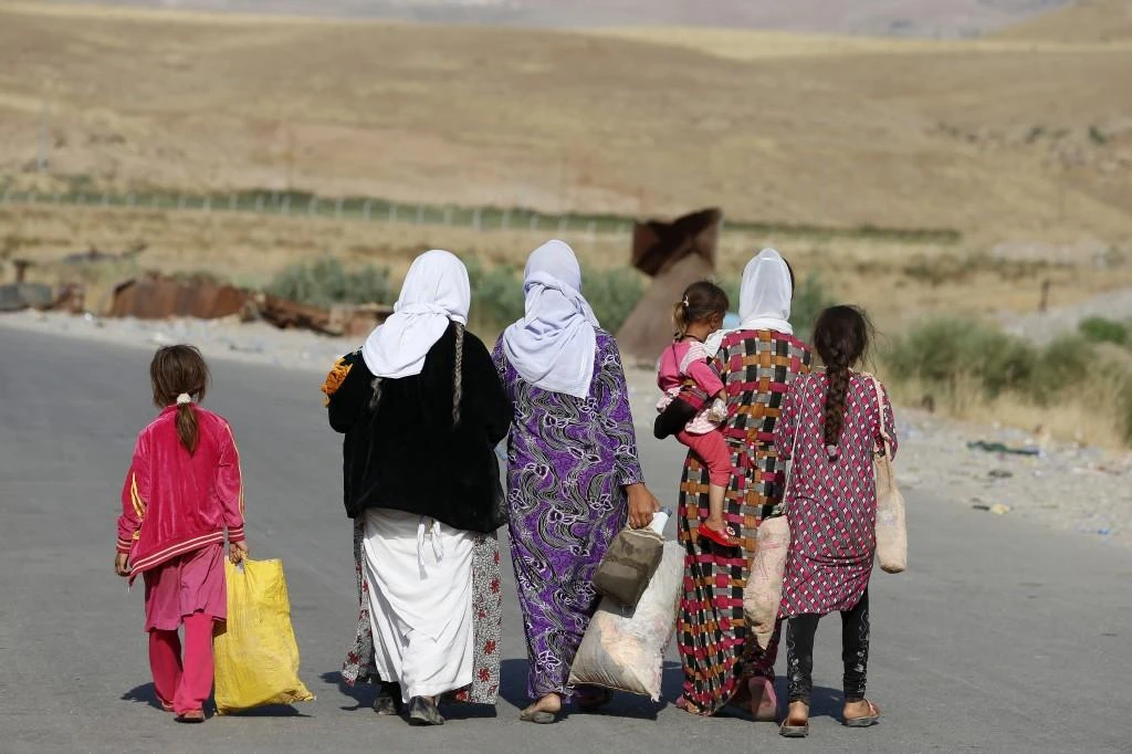 Women and children from the minority Yazidi sect, fleeing the violence in the Iraqi town of Sinjar, near the Iraqi-Syrian border crossing in Fishkhabour, Dohuk province, on August 14, 2014. (File Photo by Reuters)