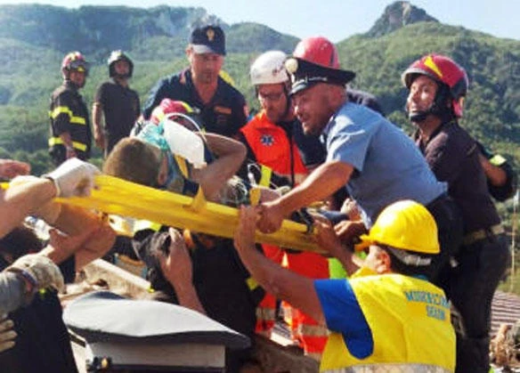 Firefighters and rescuers pull out a boy, Mattias, from the collapsed building in Casamicciola, a day after a 4.0-magnitude quake on the resort island of Ischia off Naples, Italy, on Tuesday, Aug. 22, 2017. (ANSA via AP)