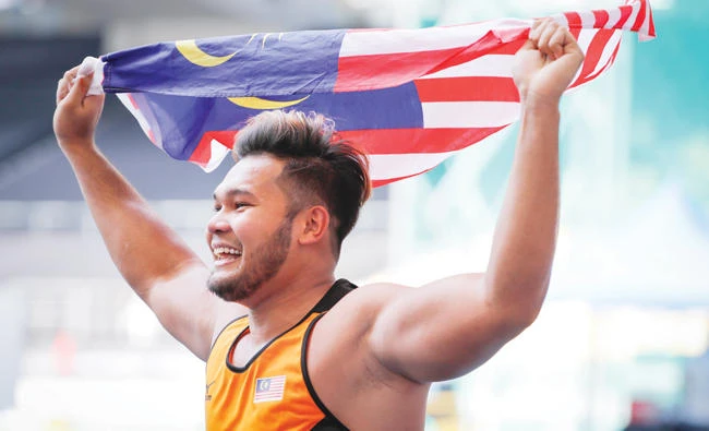 Malaysia's discus thrower Irfan Shamshuddin celebrates after winning the gold meal in men's discus throw event during the 29th South East Asian Games in Kuala Lumpur Tuesday. (AP)