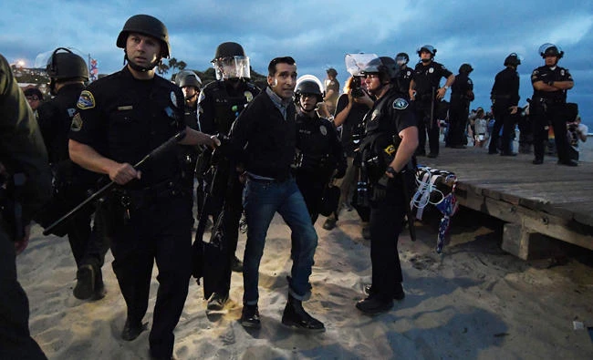 A protester is arrested after the 'America First' Pro Trump group clashed with counter protesters during dual rallies in Laguna Beach, California on August 20, 2017. (AFP)