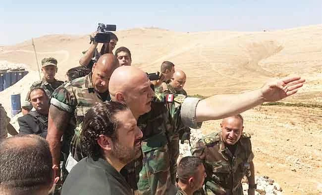 In this photo released by Lebanon's official government photographer Dalati Nohra, Lebanese Army Commander Gen. Joseph Aoun, center, explains to Lebanese Prime Minister Saad Hariri, lower center, about the situation at front line, where the Lebanese army is engaged in a battle against Daesh militants, in Das Baalbek, northeast Lebanon, on Wednesday. (AP)
