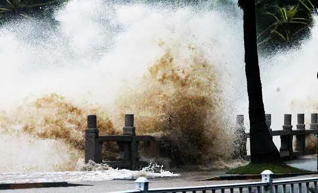 A wave caused by Typhoon Hato surges past the barrier along the seacoast in Zhuhai in China's southern Guangdong province on Wednesday. (AFP)