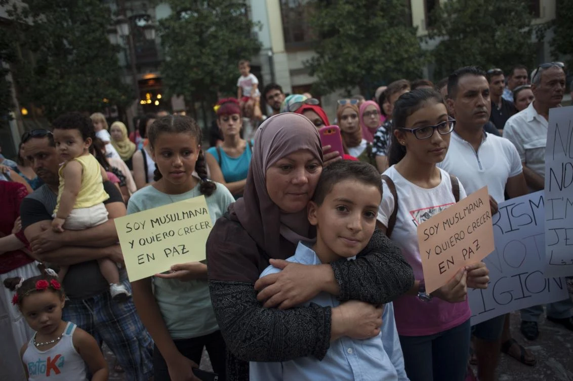 A muslim woman hugs a child during a demonstration in Granada on August 23, 2017 in protest against a surge in anti-Islamic hate crimes following last week's deadly attacks in Barcelona and Cambrils. The protest was called after the city's main mosque was attacked with flares on August 19, 2017 by a handful of members from a far-right group, Hogar Social, who also unfurled a Spanish flag outside building, according to images on Spanish TV. (AFP)