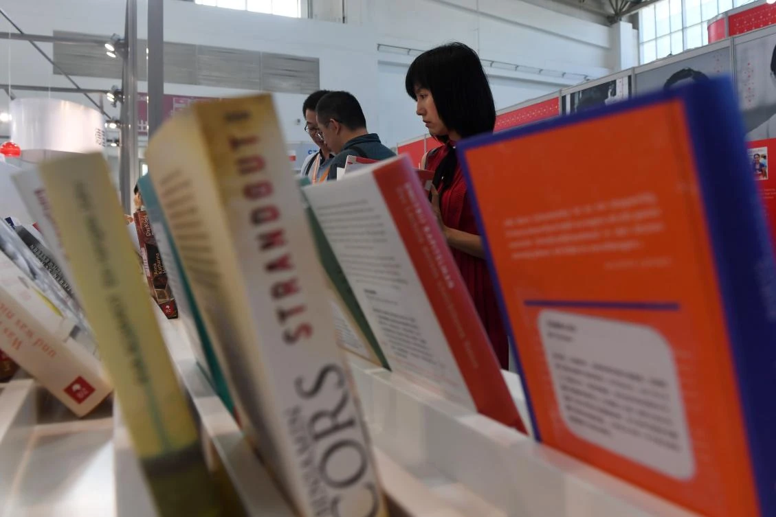 This photo taken on August 23, 2017 shows people reading books at the Beijing International Book Fair in Beijing. Just days after an outcry over an attempt to censor a British academic journal in China, hundreds of international publishing houses are courting importers at a major book fair in Beijing. (AFP)