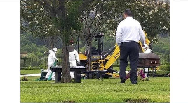 The Orange County Coroner's Office exhume the body of a man who was buried after being mistakenly identified in Orange, Calif., Wednesday, Aug. 23, 2017. (The Orange County Register via AP)