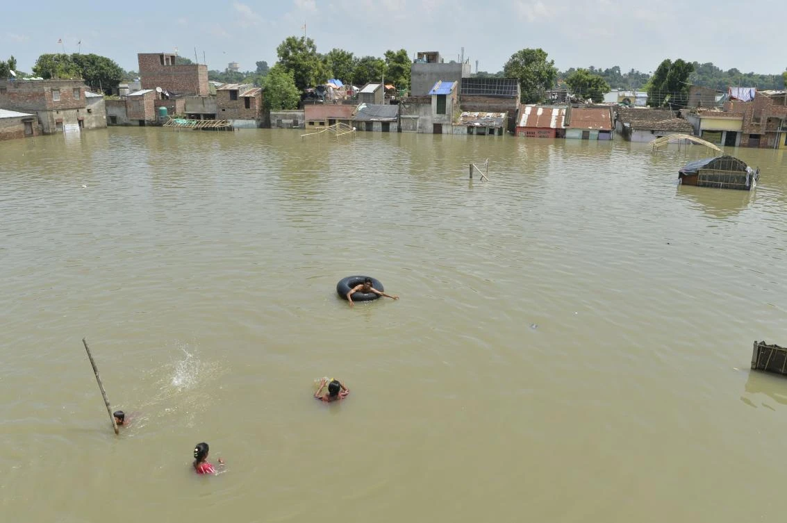 Indian residents swim and wade through flood waters in Malda in the Indian state of West Bengal, on August 24, 2017. (AFP)