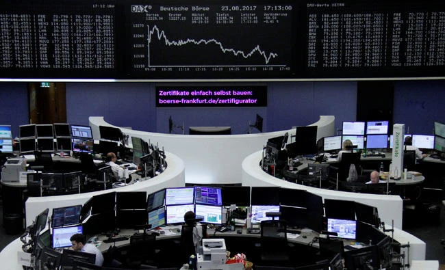 Traders work in front of the German share price index, DAX board, at the stock exchange in Frankfurt, Germany, on August 23, 2017. (REUTERS)