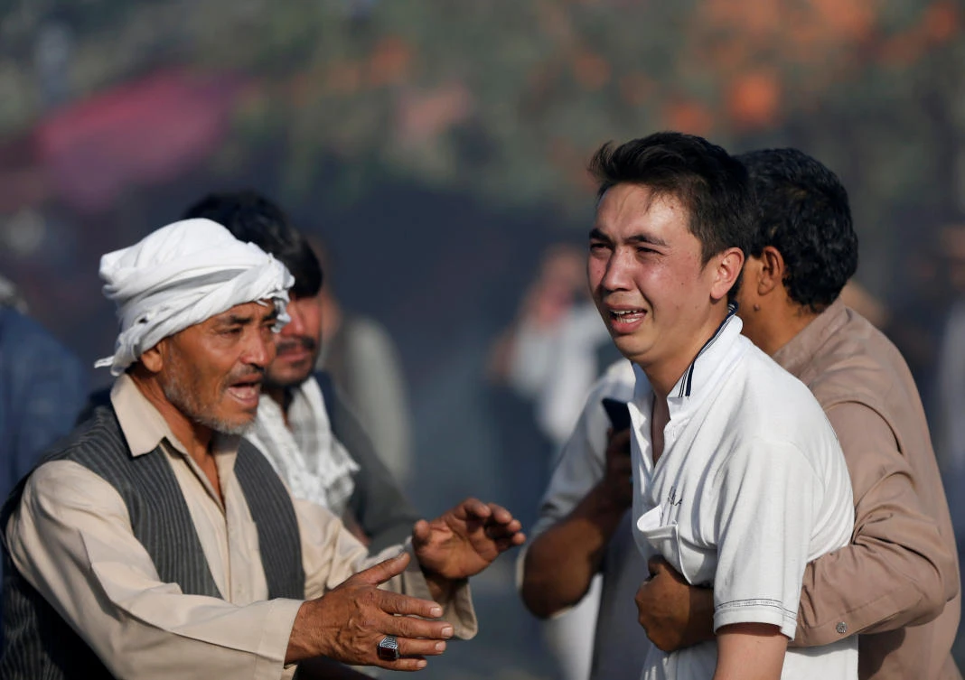 Afghan men comfort a man, after he heard his relatives were killed at the site of a suicide attack followed by a clash between Afghan forces and insurgents after an attack on a Shiite mosque in Kabul on Friday. (Reuters)