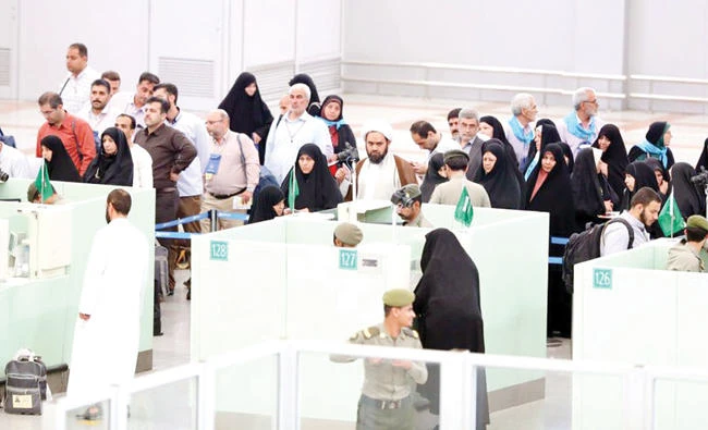 Saudi passport control officers serve Hajjis at King Abdul Aziz International Airport in Jeddah on Friday. (SPA)