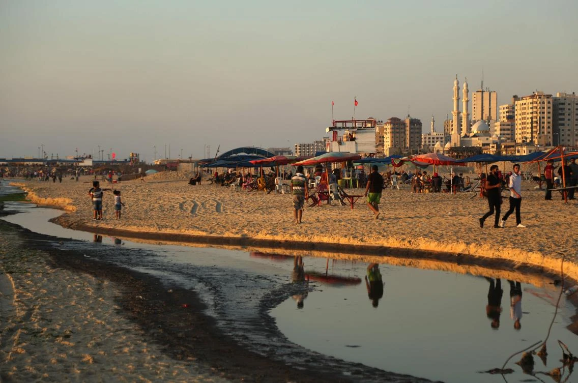 This file photo taken on July 03, 2017 shows Palestinians spending time at the beach in Gaza City next to sewage-polluted waters. The death of a little boy after swimming in polluted seawater has put the spotlight on Gaza's pollution crisis and the human impact of desperate electricity shortages in the Palestinian enclave. Pollution in Gaza is not a new phenomena -- a decade of a crippling Israeli blockade, coupled with three devastating wars with the Jewish state since 2008, have left infrastructure falling apart. (AFP)