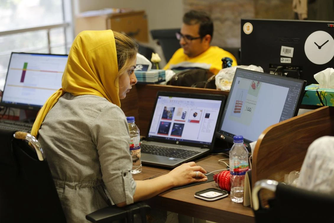 This file photo taken on July 09, 2017 shows Bamilo employees working at the e-commerce site's offices in the Iranian capital Tehran. Iranians have been joined by a minister in protest after Apple removed popular apps from its store, which the American company says has been done to comply with US sanctions. (AFP)
