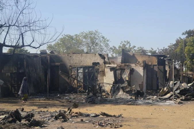 A woman walks past homes destroyed by Boko Haram militants in Bama, Borno State, on February 20, 2014. (File photo by Reuters)