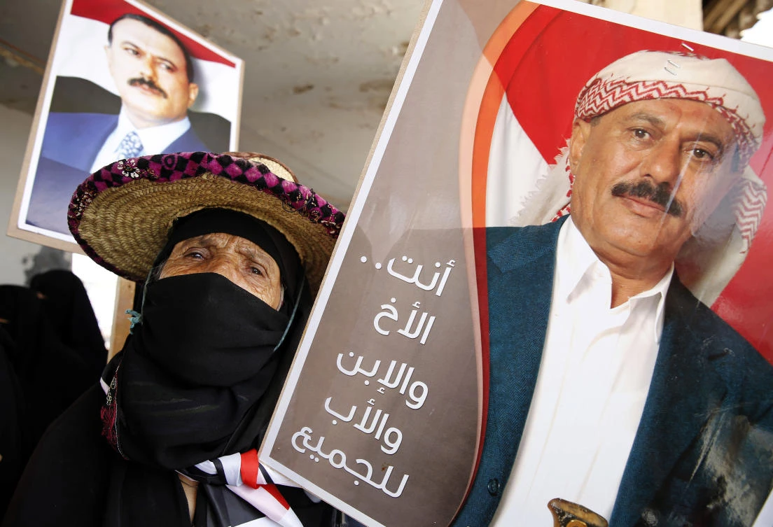 A supporter of former Yemeni President Ali Abdullah Saleh holds his photo during a rally in Sanaa, Yemen. (AP)