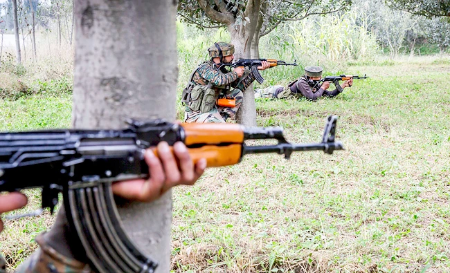Indian army soldiers take position inside an apple orchard near the site of gunbattle in Pulwama, about 35 Kilometers south of Srinagar, Indian controlled Kashmir, on Saturday. (AP)