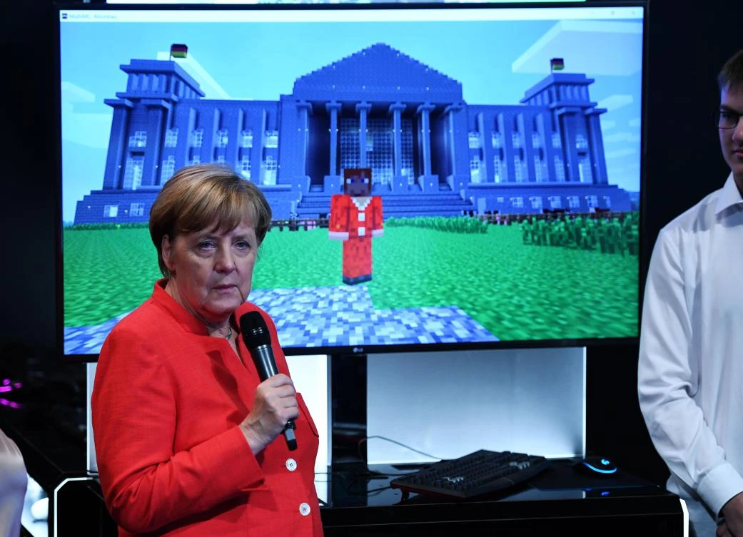 German Chancellor Angela Merkel follows a presentation of Microsoft´s Minecraft game at the stand of Microsoft during the gaming fair "gamescom" in Cologne on August 22, 2017. (AFP)