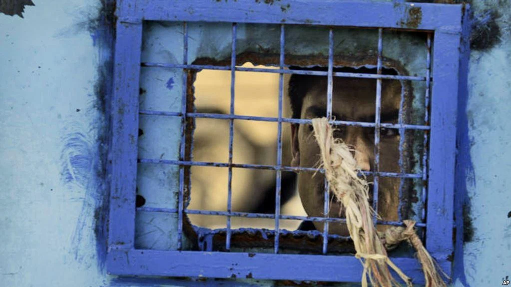 A prisoner looks out of his cell window at the main prison in Kandahar, Afghanistan. (File photo by AP)
