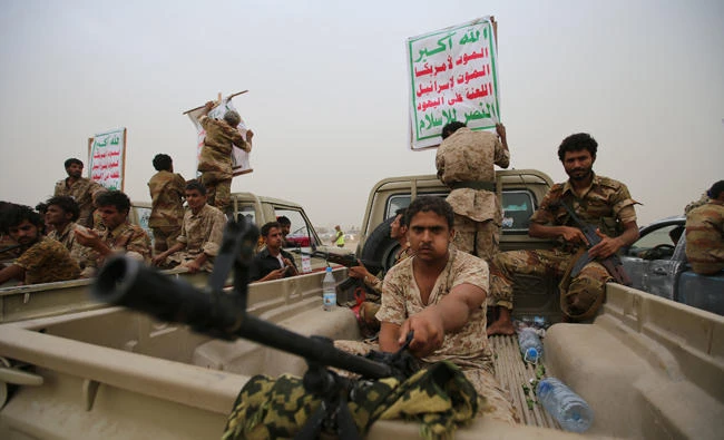 Houthi fighters ride on the back of trucks as they take part in a parade in the Red Sea port city of Hodeidah, Yemen, on August 24, 2017. The placards read: "Allah is the greatest. Death to America, death to Israel, a curse on the Jews, victory to Islam." (REUTERS/Abduljabbar Zeyad)