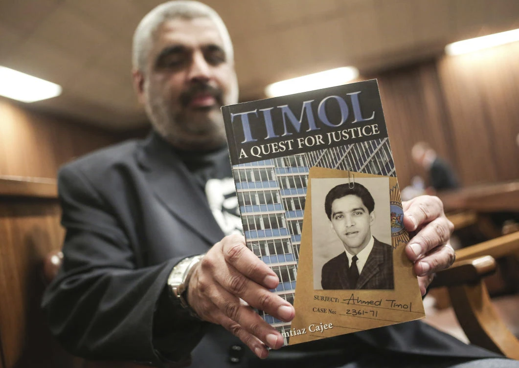 Imtiaz Cajee, nephew of Ahmed Timol, poses with his book "Timol, A Quest for Justice" in the North Gauteng High court in Pretoria, South Africa, Thursday. (AP Photo)