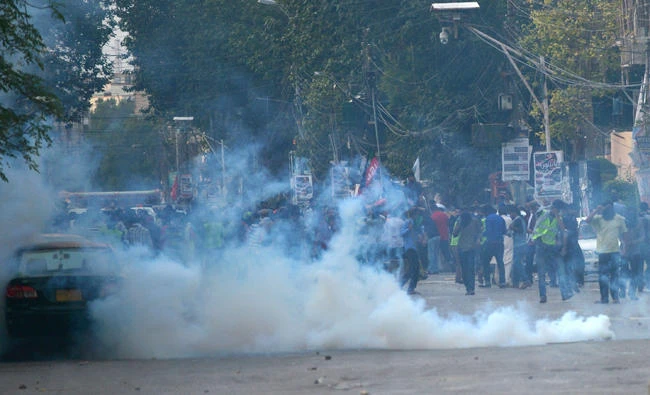 Policemen fire teargas canisters to scatter protesters marching toward the US consulate in Karachi, Pakistan, on Sunday, August 27, 2017. (AFP / Rizwan Tabassum)