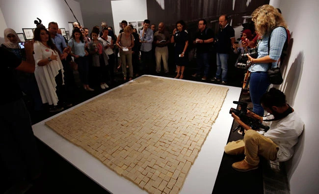 People stand next to an installation made up of soaps called “Palestine after Oslo” during a media tour ahead of the “Jerusalem Lives” exhibition at the Palestinian Museum on Saturday in the West Bank town of Birzeit, near Ramallah. (AFP)