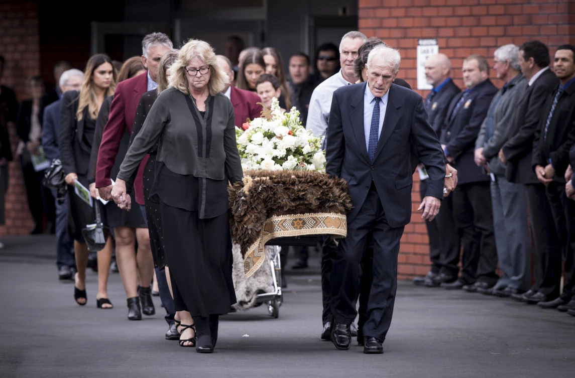The casket of All Blacks legend Colin Meads is carried by family following his funeral service in his home town of Te Kuiti, New Zealand, on August 28, 2017. (New Zealand Herald via AP)