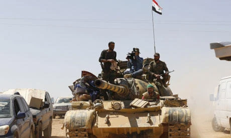 Syrian forces members sit on a tank waiting for vehicles to transport Daesh group members in the Qara area in Syria’s Qalamoun region on August 28, 2017. (AFP)