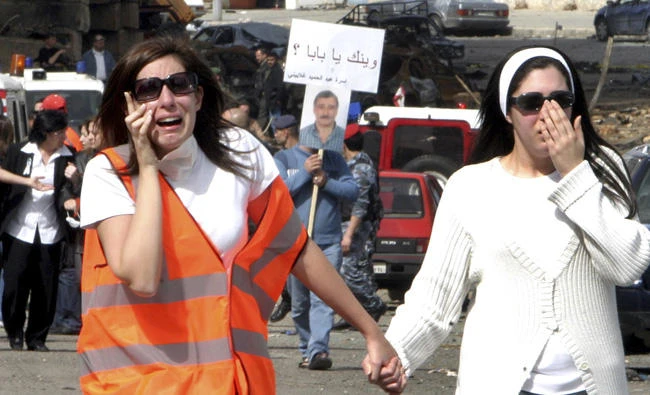 In this March 2, 2005 file photo, Lama Ghalayini, left, daughter of Addul-Hameed Mohammed Ghalaini, accompanied by an unidentified relative, cries after Civil Defense members discovered in Beirut, Lebanon, the body of her father, who was killed in the Feb. 14 explosion that left former Prime Minister Rafik Hariri and 16 other people dead. (AP Photo, File)