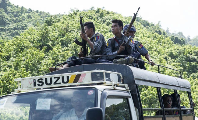 Myanmar police sit on the roof of a truck as they provide protection for staff from the United Nations (UN) and International Non-Governmental Organizations (INGOs) after a visit to a conflict area, at a check point near the entrance of Maungdaw township in Myanmar's Rakhine State on August 28, 2017. Rohingya Muslims are once more fleeing in droves towards Bangladesh, trying to escape the latest surge in violence in Rakhine state between a shadowy militant group and Myanmar's military. (AFP)
