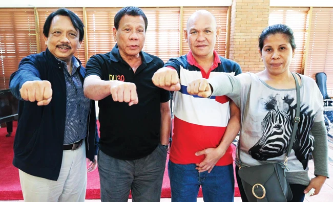 Philippine President Rodrigo R. Duterte with the parents of Kian Loyd Delos Santos, the teenager who was allegedly killed by the police during an anti-drug raid on Aug. 17.