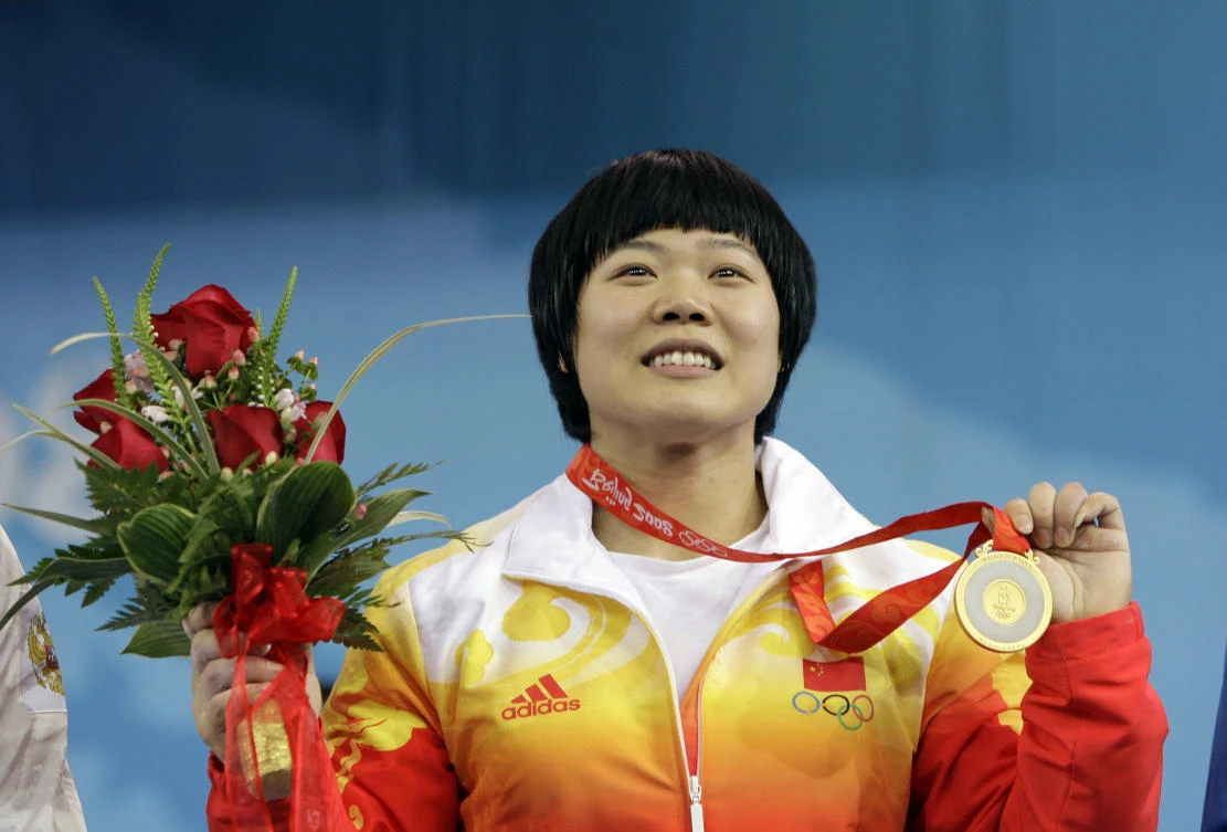 In this Aug. 13, 2008 photo, Liu Chunhong of China displays her gold medal in the women's 69 kg of the weightlifting competition at the Beijing 2008 Olympics in Beijing. The Court of Arbitration for Sport has dismissed appeals on Monday, Aug. 28, 2017 by two Chinese female weightlifters against being stripped of their 2008 Beijing Olympic gold medals for doping. (AP Photo/Andres Leighton, file)