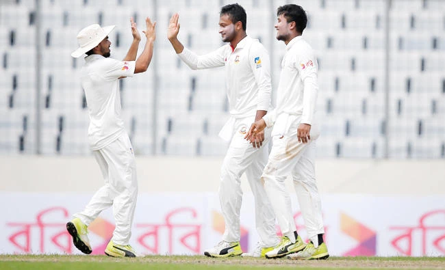 Bangladesh’s Sakib Al Hasan, center, celebrates with his teammates Sabbir Rahman, right, after the dismissal of Australia’s Glenn Maxwell during the second day of their first Test cricket in Dhaka Monday. (AP)