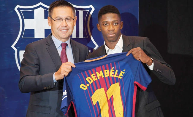 Barcelona’s new player Ousmane Dembele, right, poses with his new jersey next to Barcelona’s president Josep Maria Bartomeu at the Camp Nou stadium in Barcelona, during his official presentation at the Catalan football club, on Monday. (AFP)