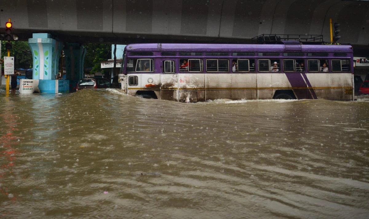 A bus with passengers drives along a flooded road during heavy rain showers in Mumbai on August 29, 2017. (AFP)