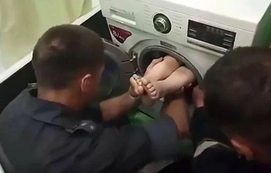 The boy’s feet can be seen sticking out of the washing machine