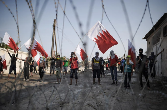 Bahraini protesters are seen raising national flags. (File photo by AFP)