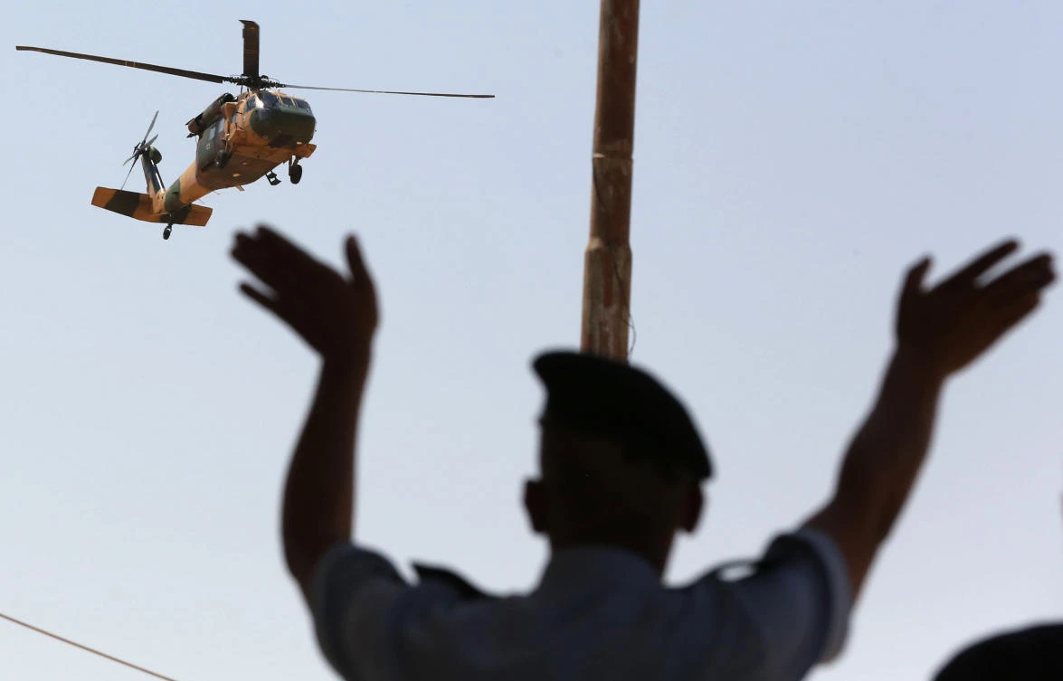 A helicopter flies over a gesturing Jordanian security guard at the Al-Karameh border point with Iraq on August 30, 2017. Jordan and Iraq reopened their only border crossing, saying security had been restored three years after the Islamic State group seized control of frontier areas. (AFP)