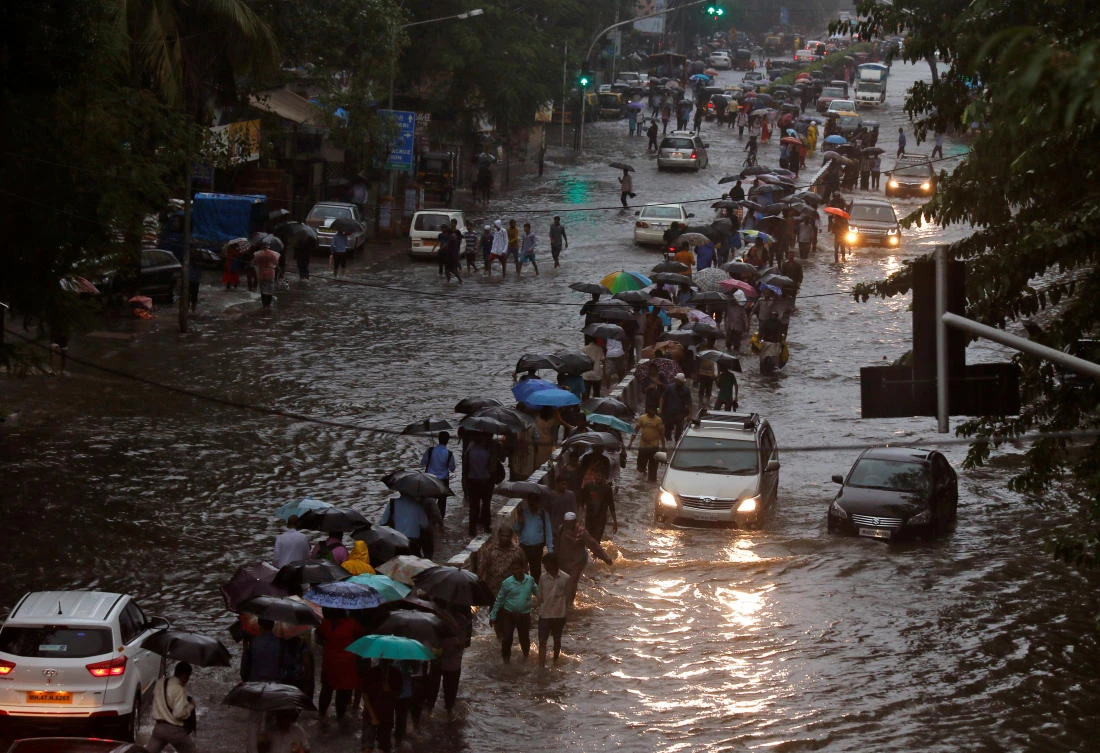 Commuters walk through water-logged roads after rains in Mumbai, India, on August 29, 2017. (File photo by Reuters)