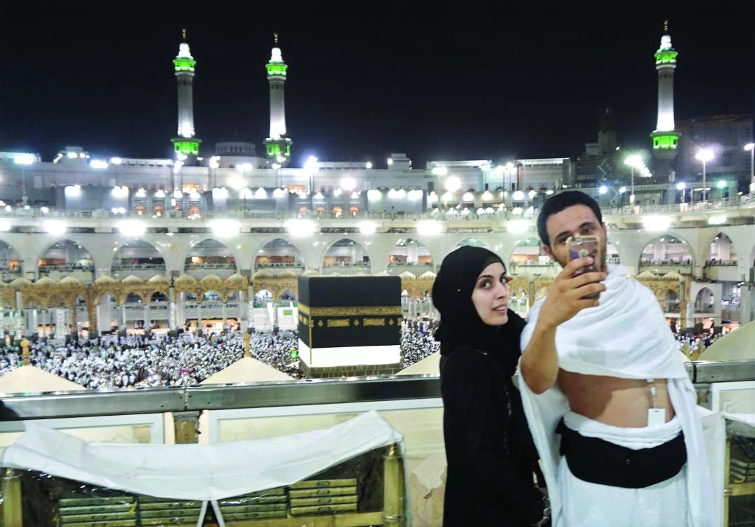 Hajj pilgrims take a selfie at the Grand Mosque in Makkah on Wednesday, on the eve of the start of the annual Hajj pilgrimage. (AFP)