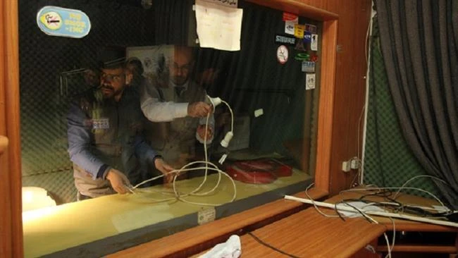 Palestinian journalists check the damage after Israeli soldiers raided the offices of a local Palestinian radio station in Hebron, on November 21, 2015. (File photo by AFP)