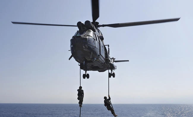Lebanese army soldiers rappel down from a helicopter onto the deck of the Brazilian warship UNIAO, part of the UNIFIL Maritime force, during a joint training to apprehend the smuggling of illegal material, off the coast of Beirut, Lebanon, on Aug. 23, 2017. T(AP Photo/Hussein Malla)