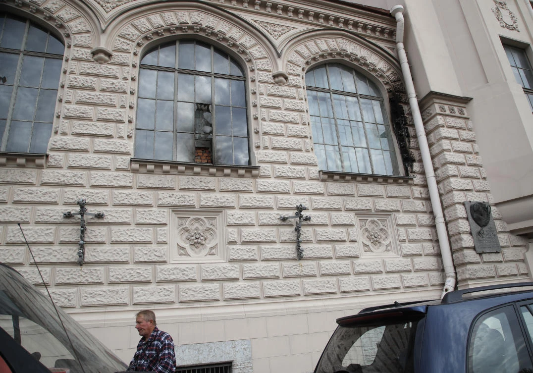 A man walks past damaged windows of a building housing the studios of director Alexei Uchitel after unidentified assailants attempted to set fire to this building in St.Petersburg, Russia, Thursday, Aug. 31, 2017. Police in St. Petersburg say they are searching for unidentified assailants who have attempted to set fire to a building housing the studios of director Alexei Uchitel whose film "Matilda," about the last Russian czar's affair with a ballerina has fueled controversy. (AP Photo/Dmitri Lovetsky)