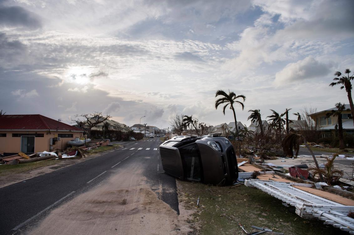 TOPSHOT - A wrecked car remains on the road of Baie Nettle area of Marigot, on September 10, 2017 on Saint-Martin island, devastated by Hurricane Irma. People on the islands of Saint Martin and Saint Barts turn to the colossal task of rebuilding after Hurricane Irma laid waste to their infrastructure and shattered their lives. / AFP / Martin BUREAU
