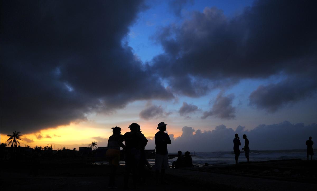 Locals enjoy sunset after the passage of Hurricane Irma, in Cojimar neighborhood in Havana, on September 10, 2017. Residents of Cuba's historic capital Havana were waist-deep in floodwaters after Hurricane Irma, on its way to Florida, swept by, cutting off power and forcing the evacuation of more than a million people. / AFP / YAMIL LAGE