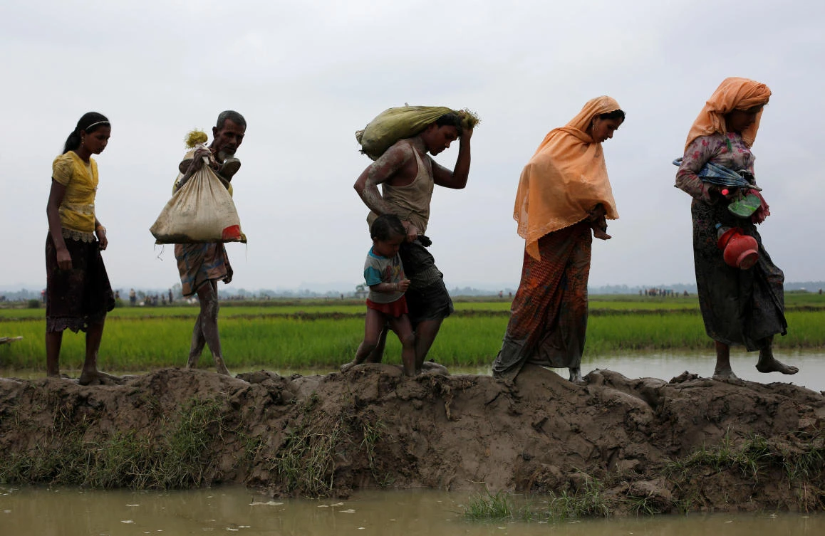 Rohingya refugees walk on a muddy path after crossing the Bangladesh-Myanmar border, in Teknaf, Bangladesh, September 6, 2017. REUTERS/Danish Siddiqui