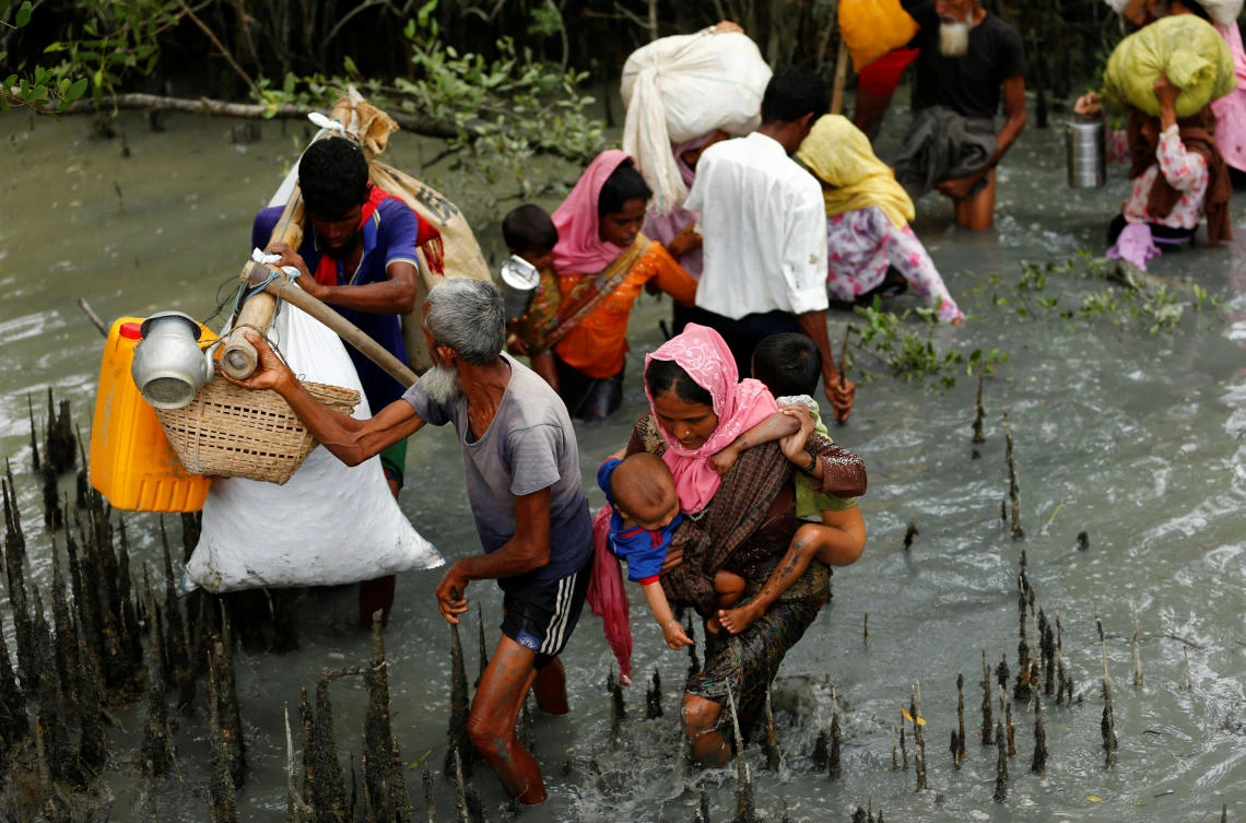 Rohingya refugees walk through water after crossing border by boat through the Naf River in Teknaf, Bangladesh, September 7, 2017. REUTERS/Mohammad Ponir Hossain