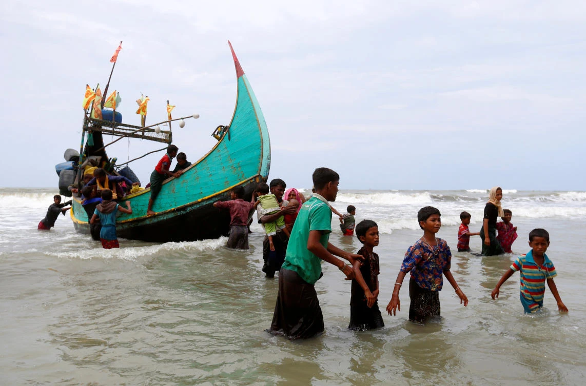 Rohingya refugees walk to the shore after crossing the Bangladesh-Myanmar border by boat through the Bay of Bengal in Teknaf, Bangladesh September 7, 2017. REUTERS/Danish Siddiqui